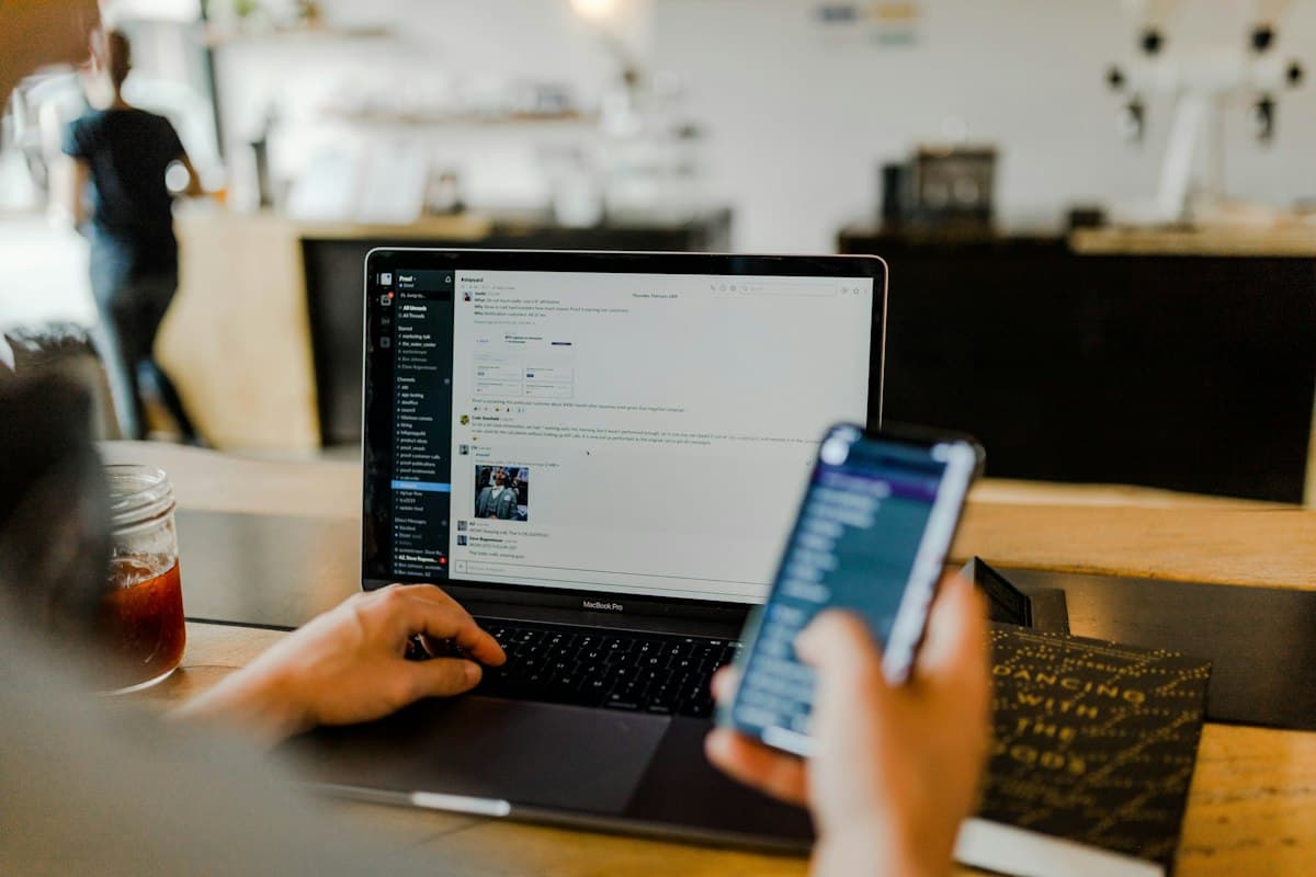 Hands on a phone and a laptop